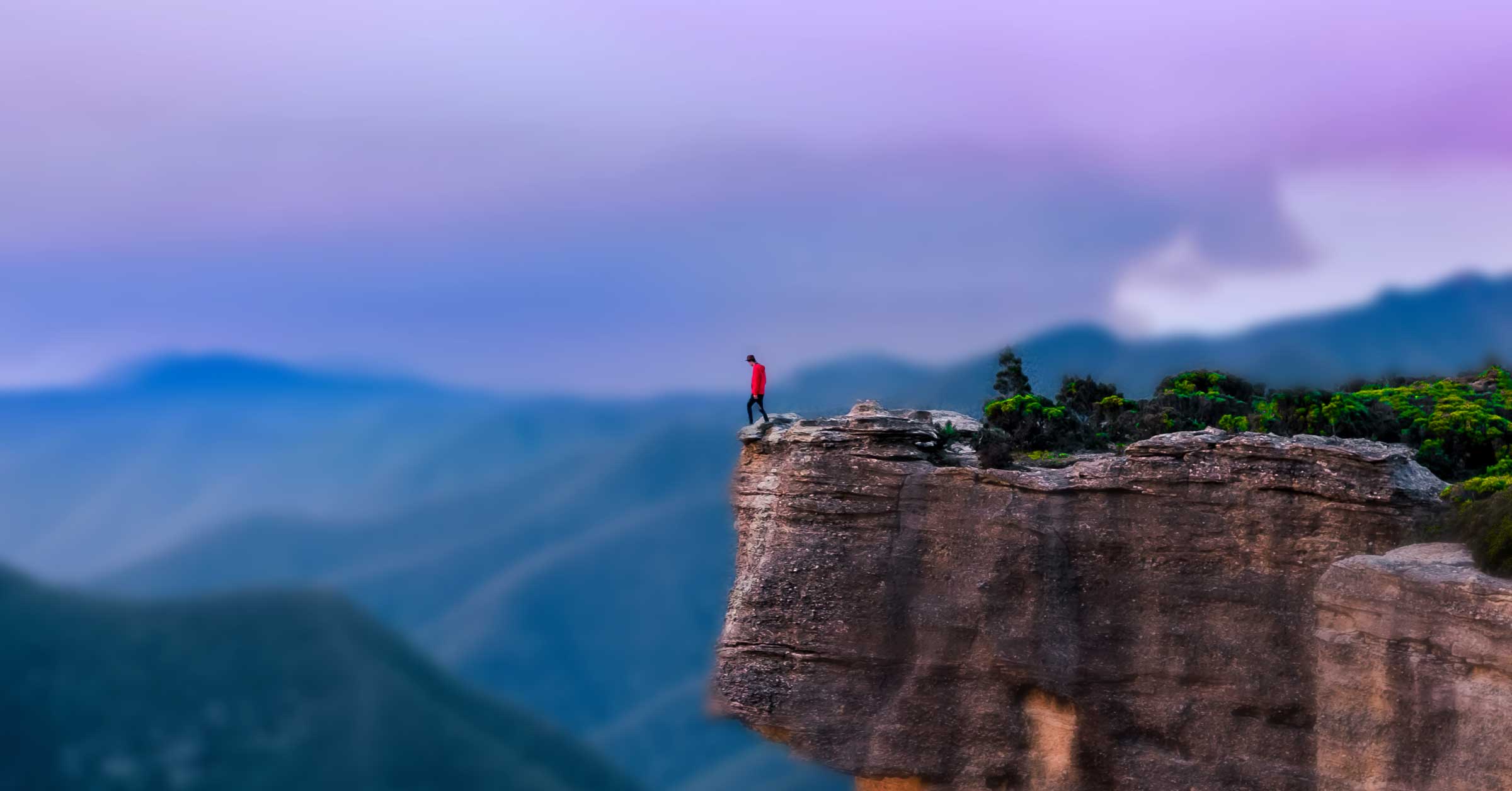 photo of man standing alone on a mountain top